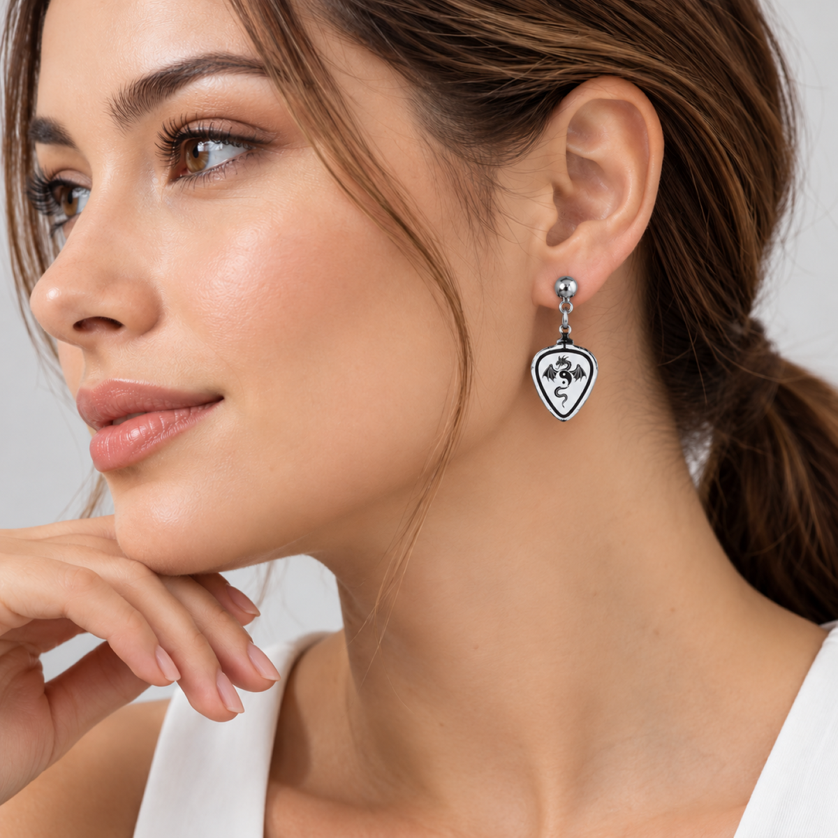 Pair of Glass Baron guitar pick earrings with black dragon designs, silver-tone drop components, and hypoallergenic posts