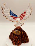 Handcrafted glass eagle with USA flag wings and gold accents standing on rocky base marked US 