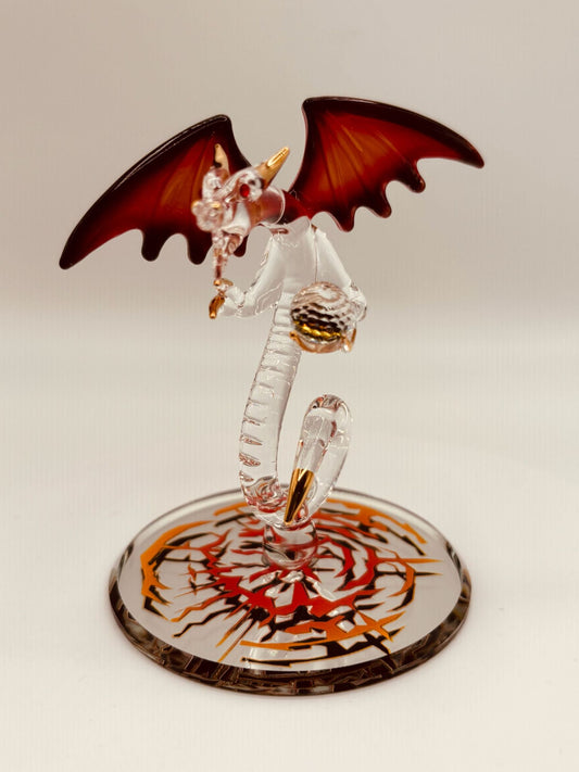 Handcrafted glass dragon with red wings holding a crystal ball on beveled mirror base with crystal and gold accents