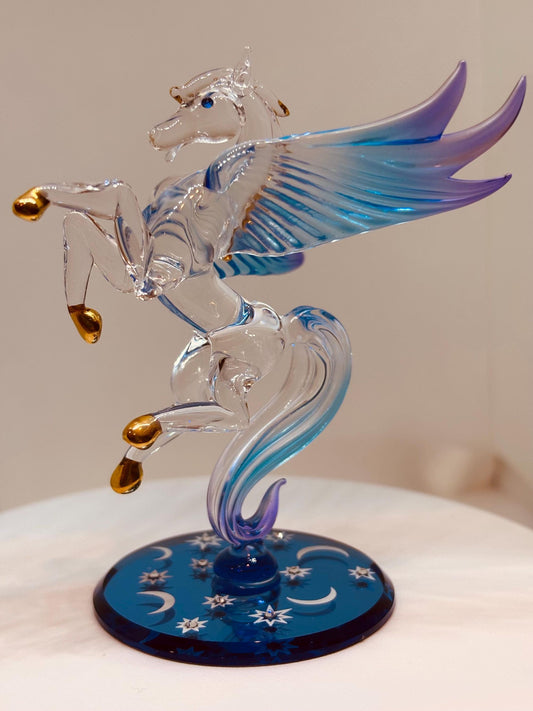 Handcrafted glass Pegasus figurine among the stars with crystal and gold accents on a blue mirror base