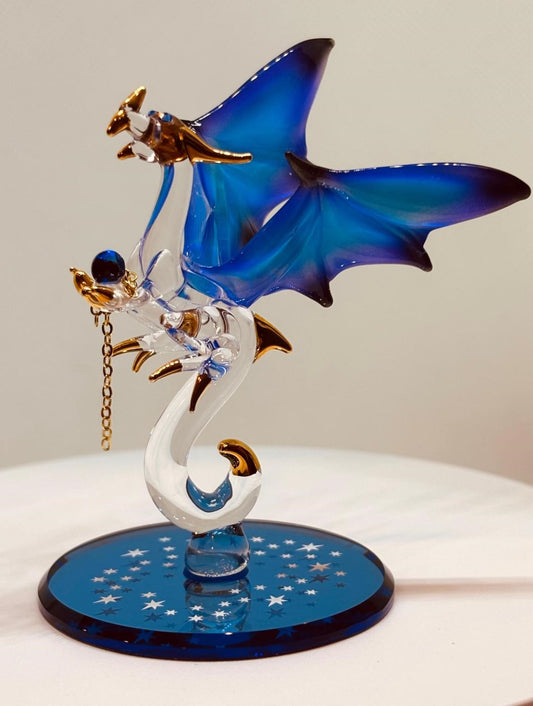Handcrafted glass dragon figurine with blue wings holding a crystal gem on a blue beveled mirror base
