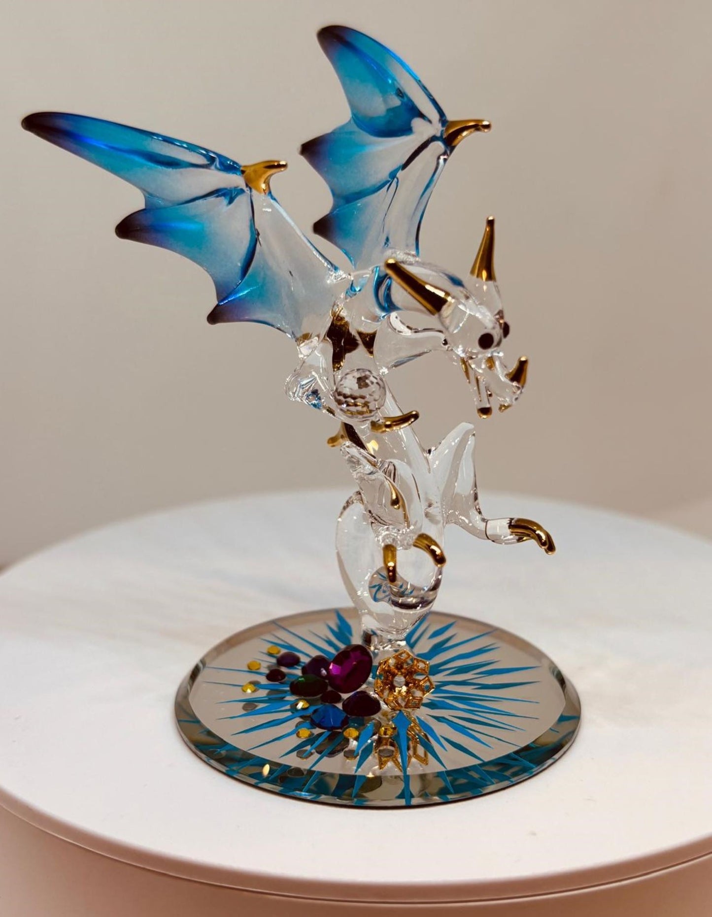 Handcrafted Jewel Keeper Dragon glass figurine with blue wings holding a gem on a beveled mirror base