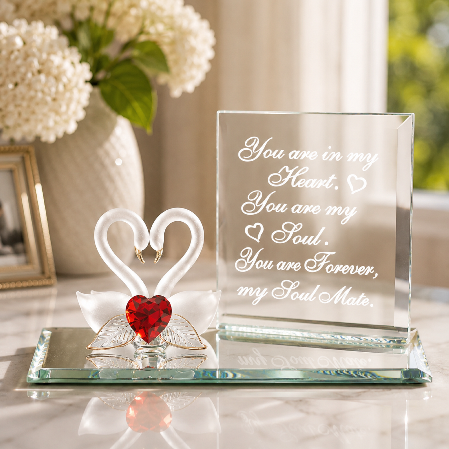 Handcrafted pair of swan glass figurines with red heart crystal centerpiece on a beveled mirror base with soulmate message and gold accents.