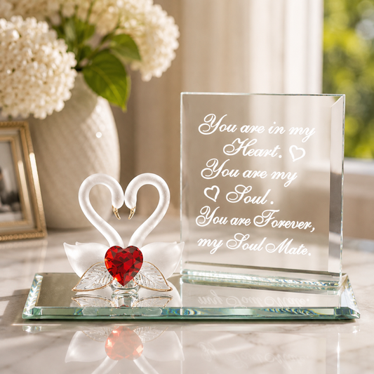 Handcrafted pair of swan glass figurines with red heart crystal centerpiece on a beveled mirror base with soulmate message and gold accents.