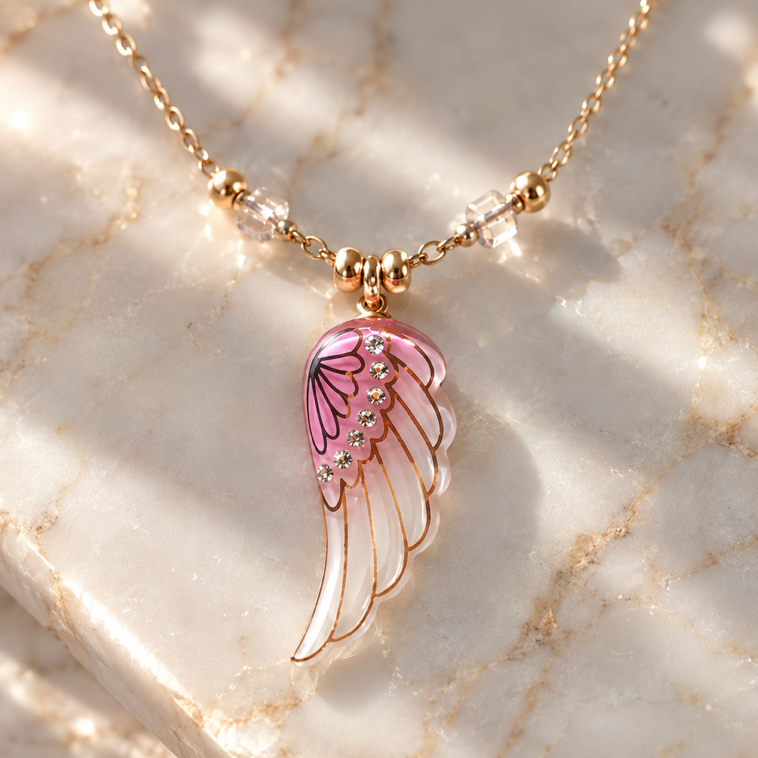Handcrafted pink glass angel wing pendant necklace with crystal accents on an 18-inch gold plated chain.
