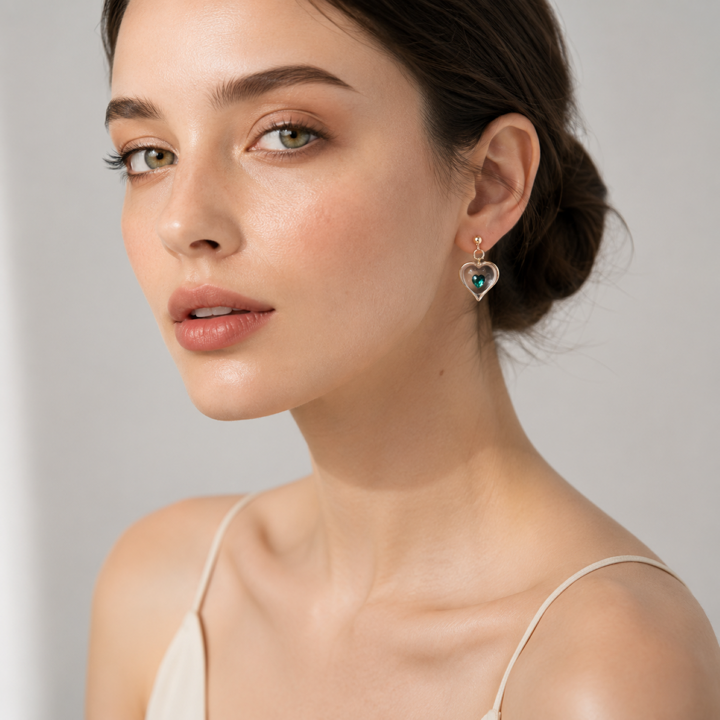 Handcrafted May birthstone heart stud earrings with green Genuine Crystal accents and Real 22Kt Gold detailing.