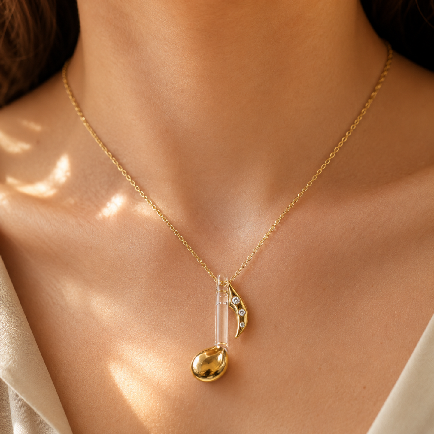 Handcrafted gold music note pendant necklace with genuine crystal accents on an 18-inch gold-plated chain.