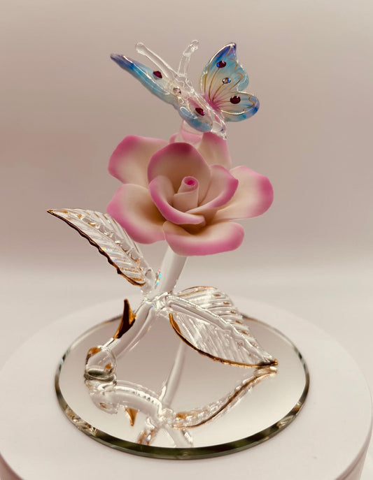 Glass butterfly figurine perched on pink rose with gold accents