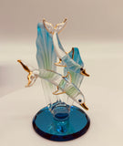 Handcrafted glass dolphin and baby swimming among sea grass on a blue beveled mirror base with crystal and 22Kt gold accents