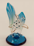 Handcrafted glass sea turtle swimming through sea grass on a blue beveled mirror base with crystal and gold accents