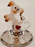 Handcrafted white and brown dog figurine sitting in a glass coffee cup on beveled mirror base with “I ♥ Dogs” message