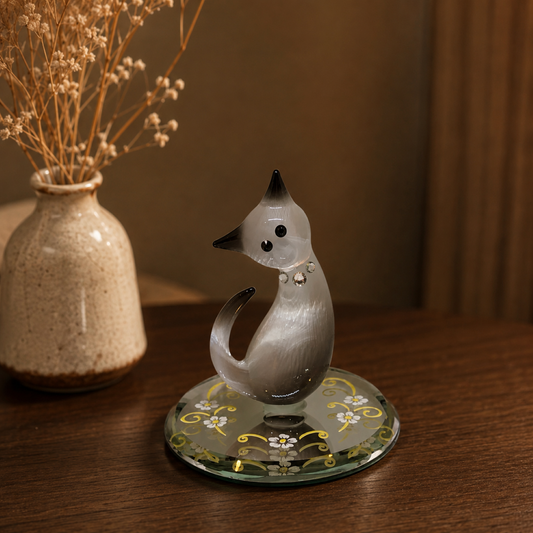 Handcrafted black and white glass cat figurine with crystal accents displayed on a decorative beveled mirror base.