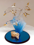 Handcrafted glass dolphin and baby figurine on blue coral with shells and gold accents