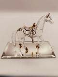 Handcrafted glass horse figurine with saddle on a beveled mirror base with crystal and gold accents