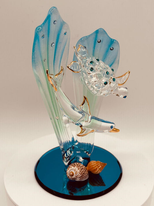 Handcrafted glass dolphin and turtle swimming among seagrass on a blue beveled mirror base with crystal and 22Kt gold accents