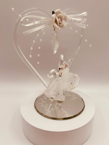 Handcrafted glass anniversary heart figurine with bells and “Happy Anniversary” embossing on beveled mirror base with crystal accents