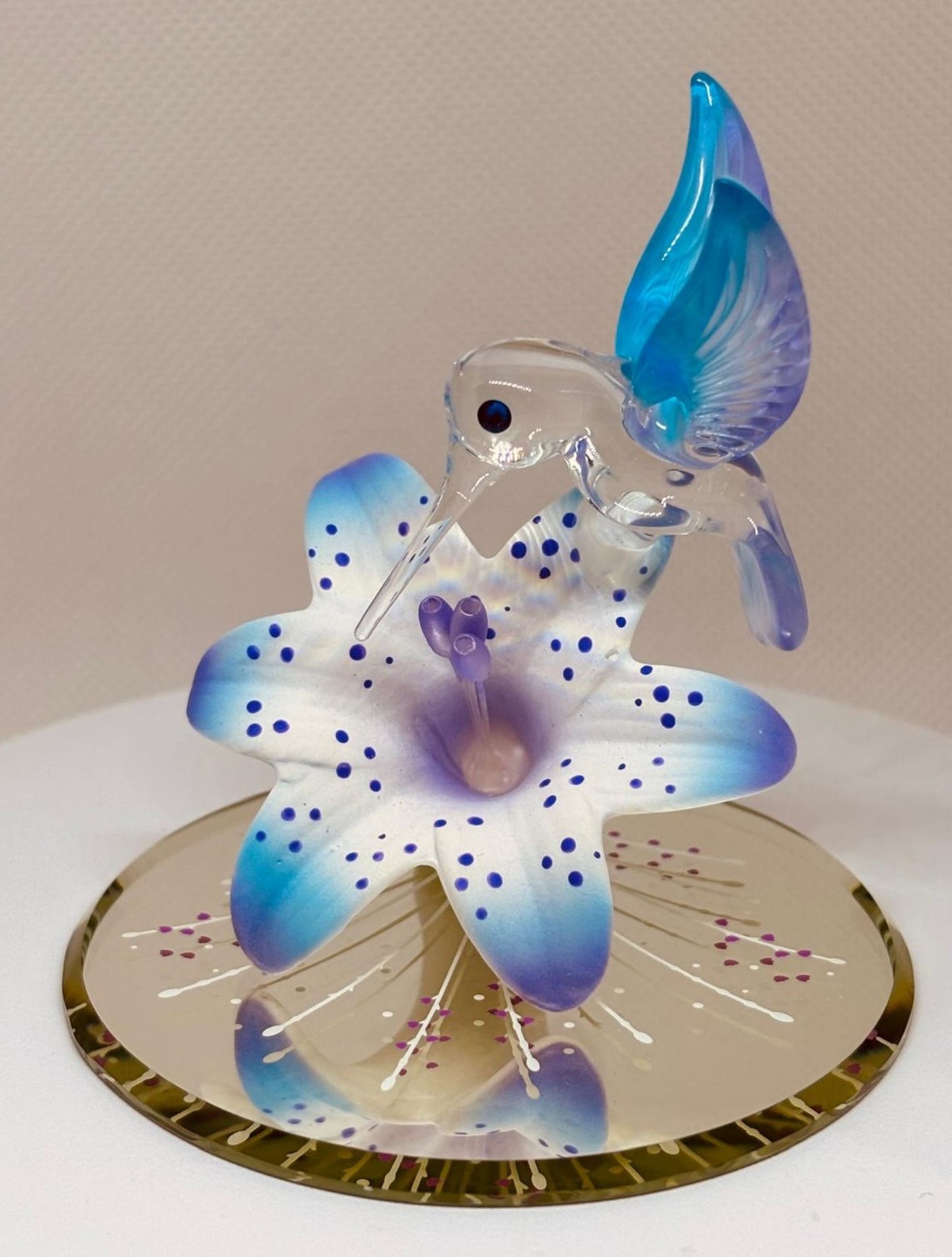 Handcrafted hummingbird figurine perched on a lily with crystal accents