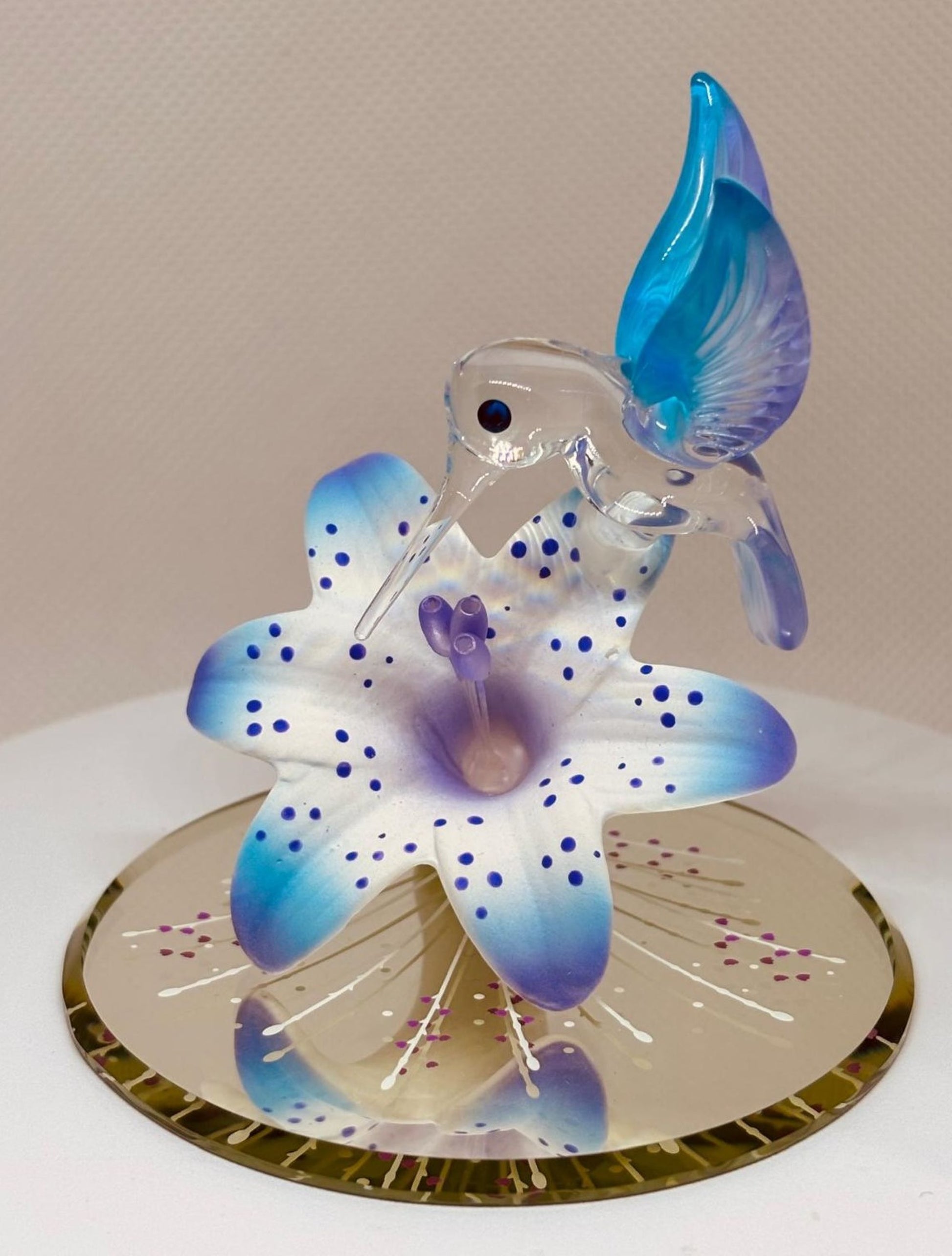 Handcrafted hummingbird figurine perched on a lily with crystal accents