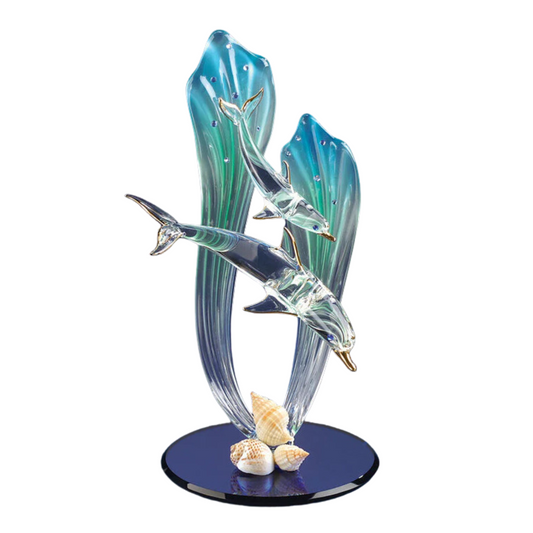 Handcrafted glass dolphin and baby swimming through blue sea grass on a beveled mirror base with crystal and gold accents