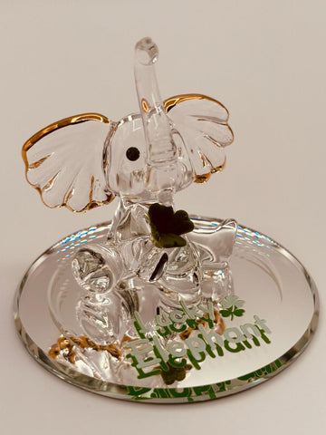 Handcrafted glass lucky elephant figurine with green crystal eyes and clover accents on beveled mirror base